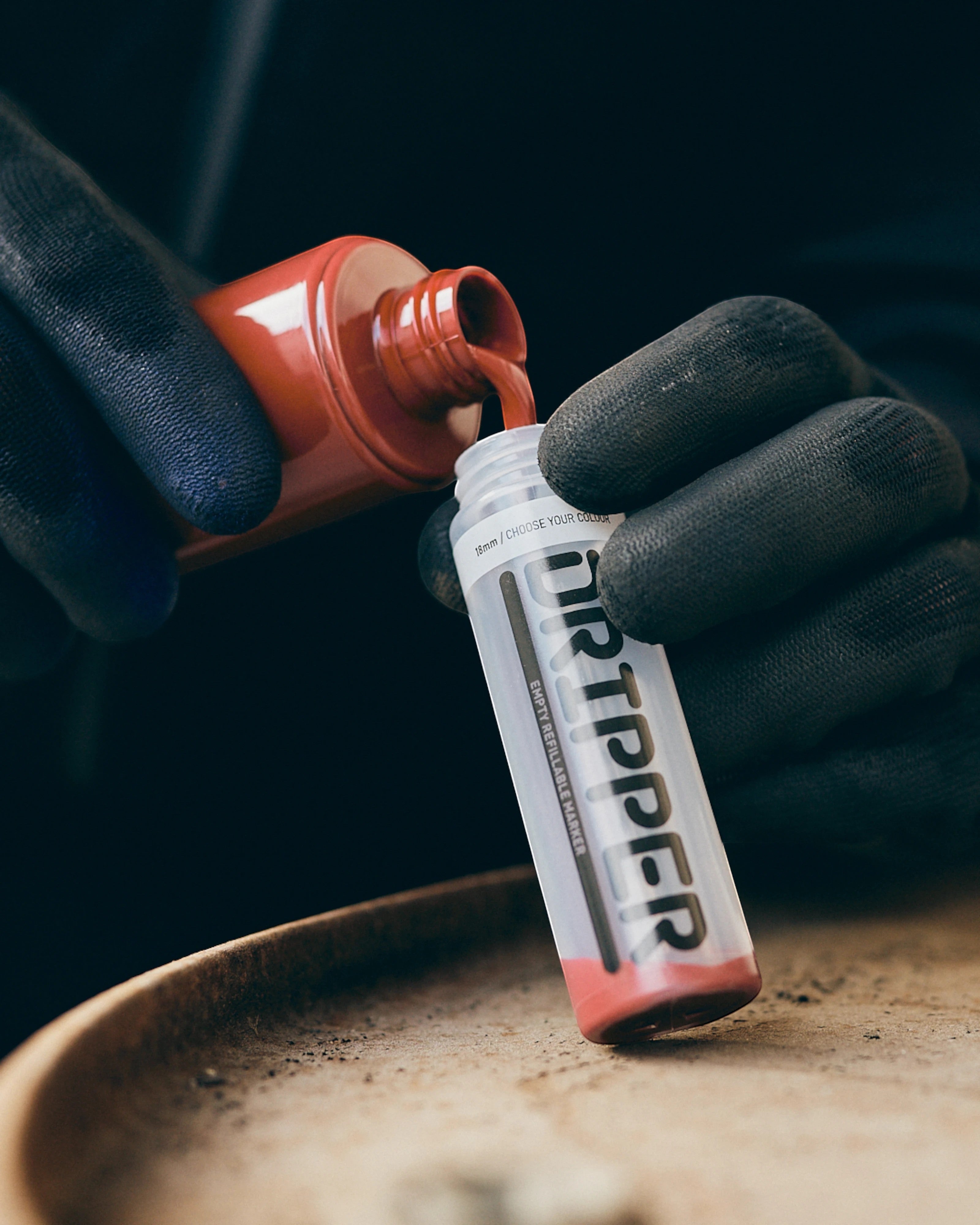 Astrofat Dope Dripper 18mm tagging marker being refilled with red ink from a bottle. Squeezable body.