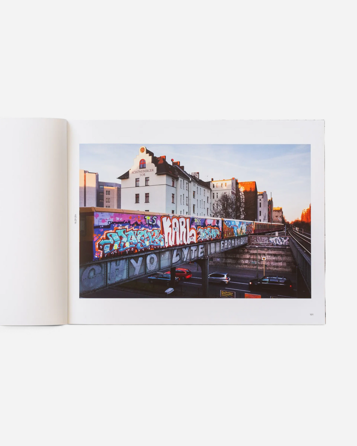 Astrofat Farbzüge book open to a page showing a vibrant graffiti-covered train passing through Berlin city streets.