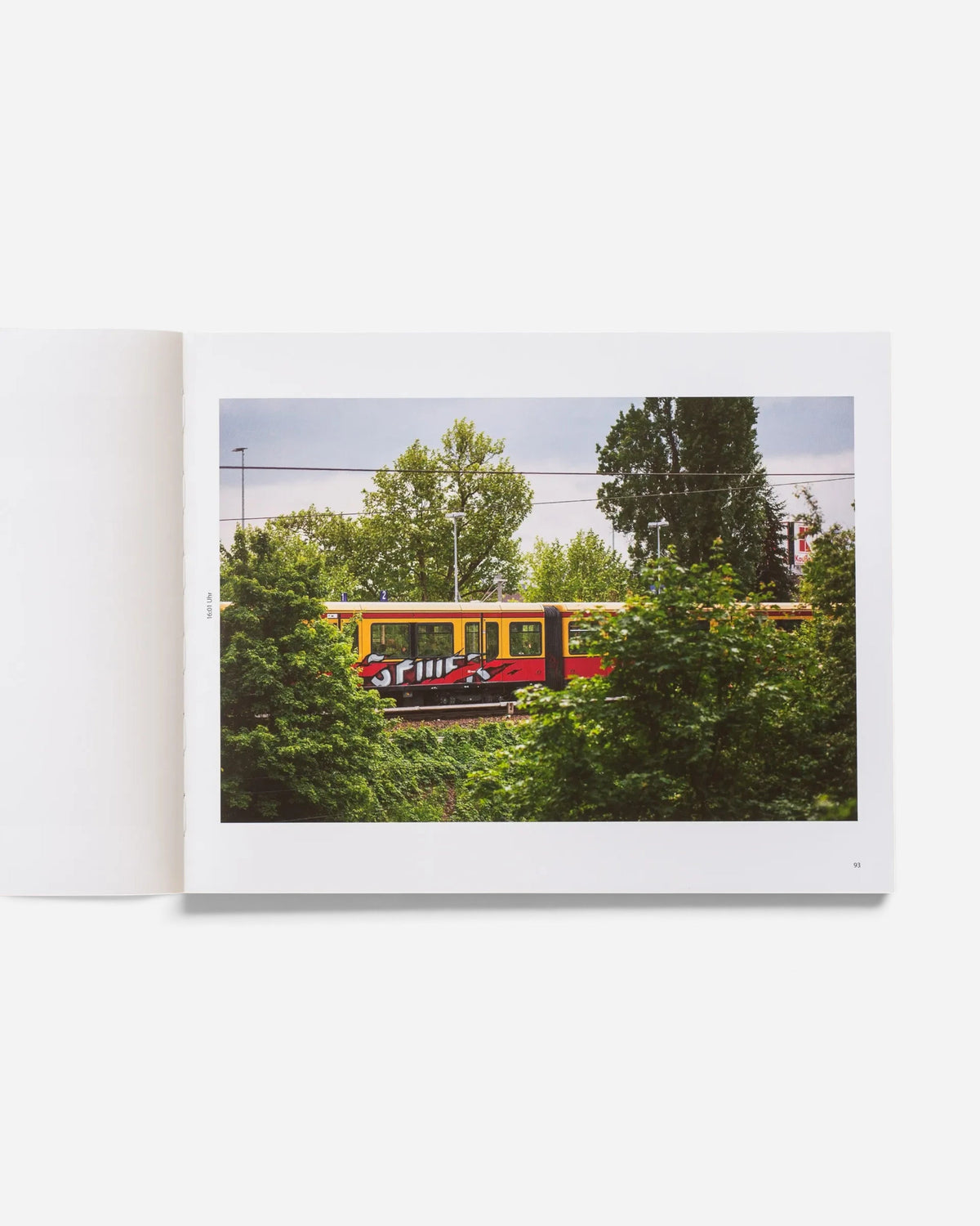 Astrofat Farbzüge book page showing a graffiti-covered Berlin train moving through a lush green landscape.