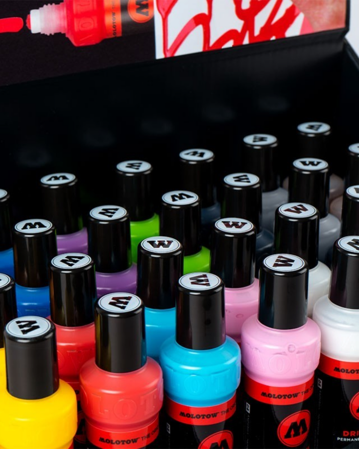 Astrofat Molotow Dripstick sales display featuring a variety of colorful permanent paint markers in a black box.