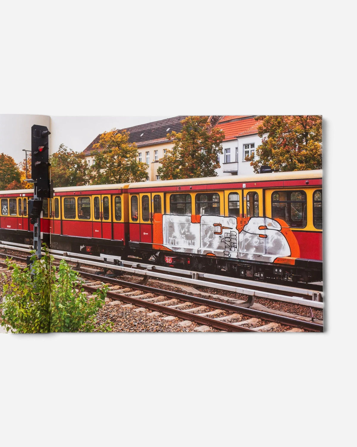 Astrofat Schriftzüge photo book open to a page showing a red and yellow Berlin S-Bahn train with graffiti art