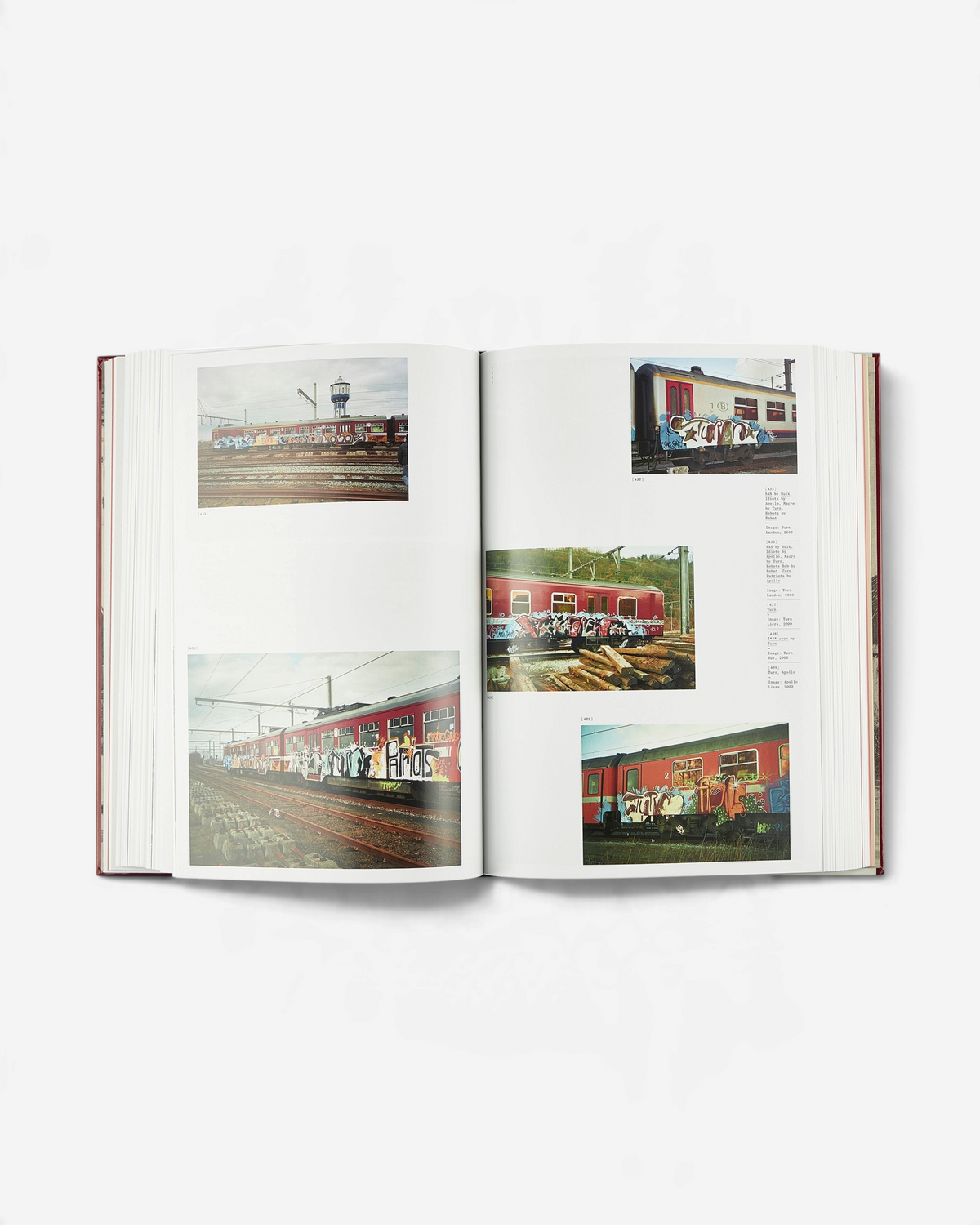 Astrofat Tales From Belgium art book open to a spread featuring photographs of graffiti-covered trains in Belgium.